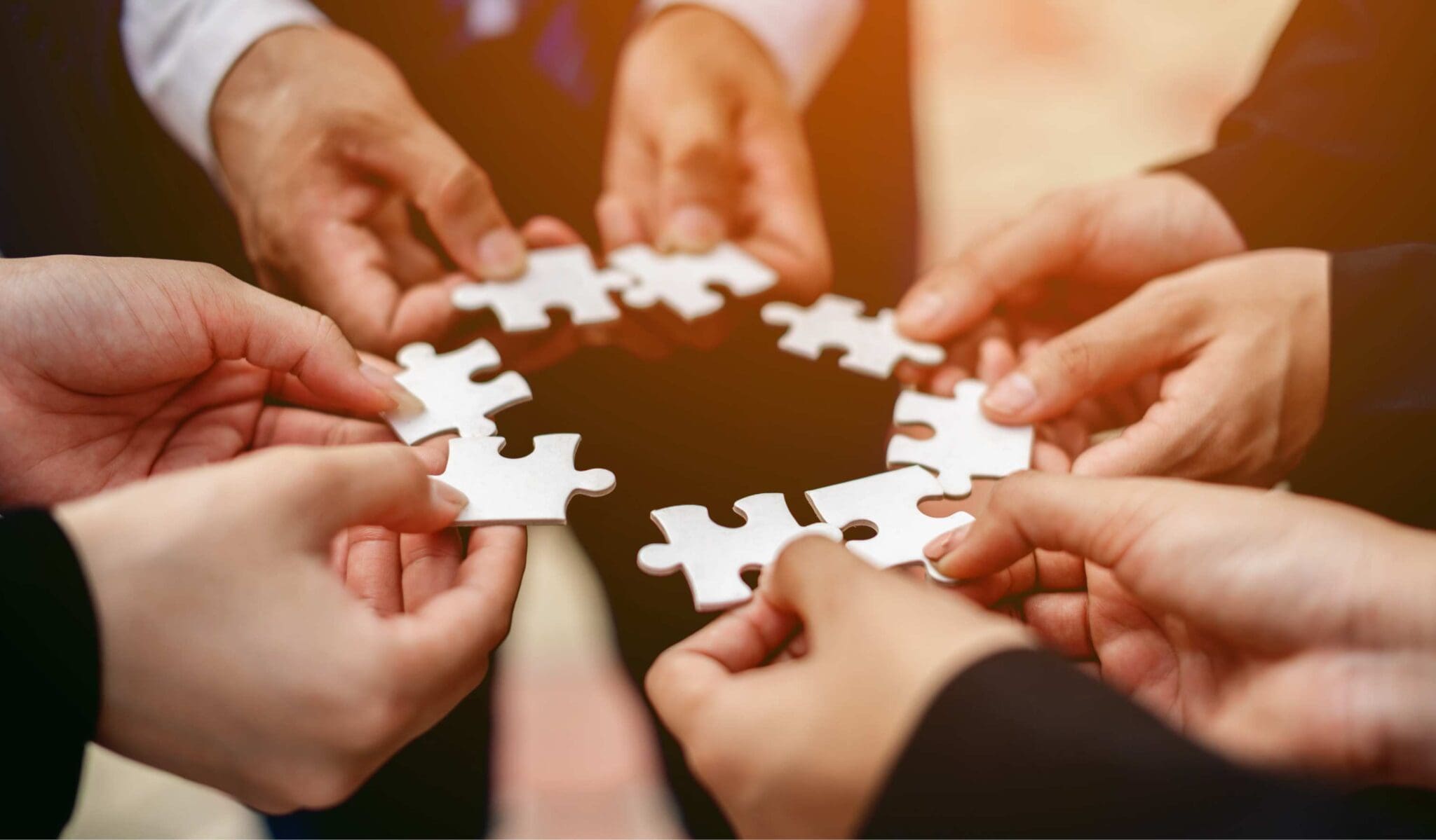Teamwork, hands holding puzzle pieces.